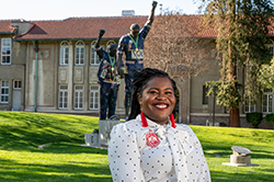 Black female in white blouse in front of Victory statue at 菠菜网lol正规平台