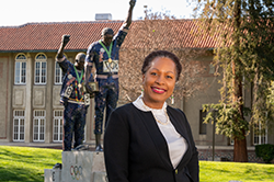 Black female in suit in front of Victory statue at San Jose State University