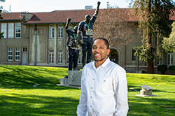 Black male in white dress shirt in front of Victory statue at 菠菜网lol正规平台